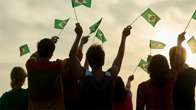 pessoas com a bandeira do Brasil nas mãos